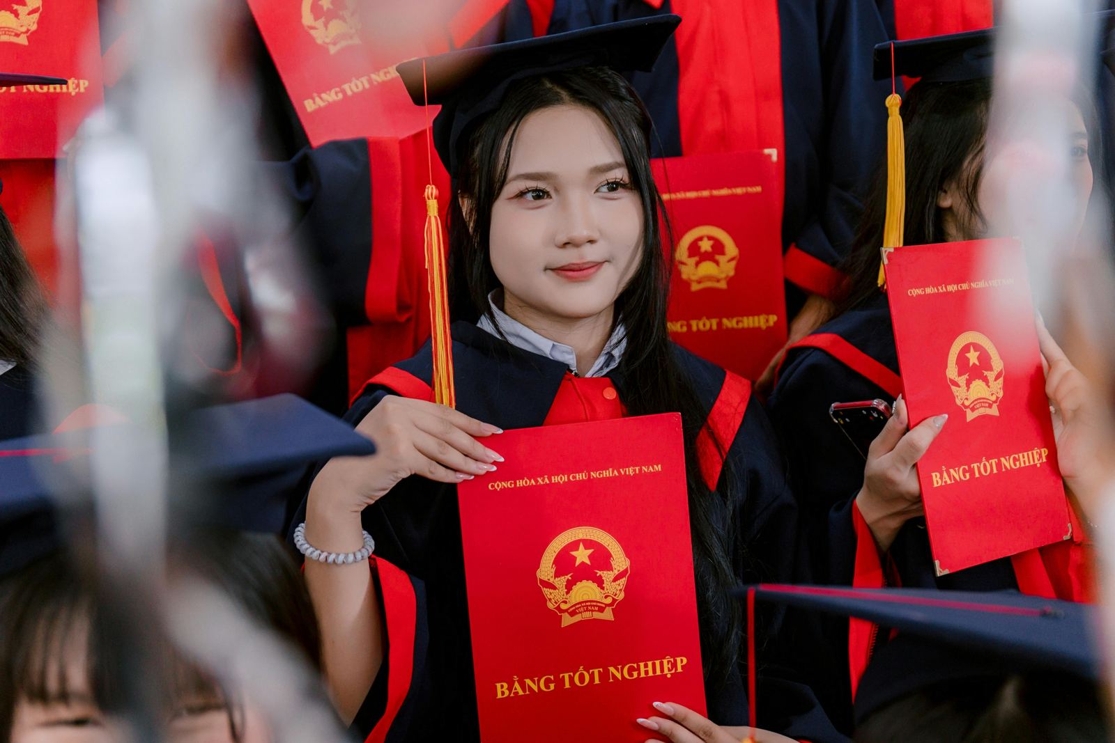 Graduate holding a diploma during a Vietnamese graduation celebration